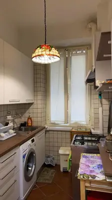 a kitchen with a washing machine and a light at Colosseum home in Rome