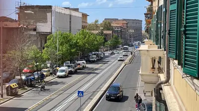 a view of a city street with cars parked on the road at Colosseum home in Rome
