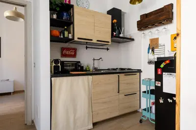 a kitchen with wooden cabinets and a refrigerator at La Dolce Vita - Testaccio Authentic District 2 in Rome