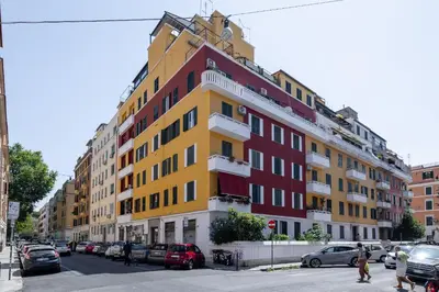 a yellow and red building on a city street at La Dolce Vita - Testaccio Authentic District 2 in Rome