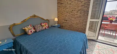 a bedroom with a blue bed with a brick wall at Vatican Roma Caput Mundi in Rome