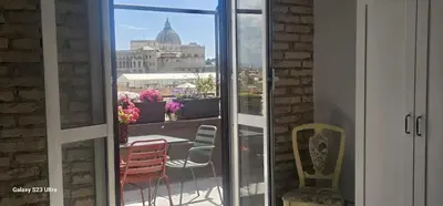 a balcony with chairs and a view of a building at Vatican Roma Caput Mundi in Rome