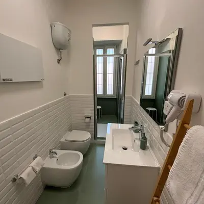 a white bathroom with a sink and a toilet at The Place Milizie in Rome