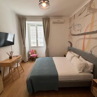 a bedroom with a bed and a desk and a television at The Place Milizie in Rome