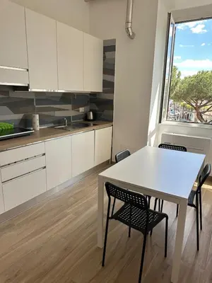 a kitchen with a white table and chairs and a window at Lotto 10 in Rome