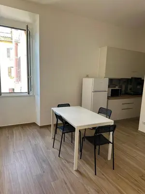 a kitchen with a table and two chairs and a refrigerator at Lotto 10 in Rome
