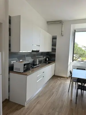 a kitchen with white cabinets and a table and a window at Lotto 10 in Rome
