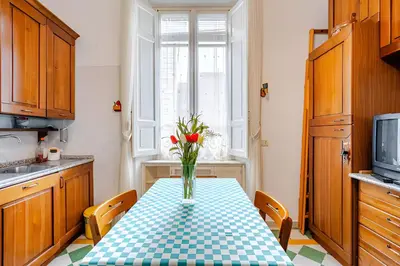 a kitchen with a table with a vase of flowers on it at S.Pietro Elvira's retro apartment in Rome