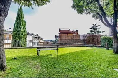 a park bench sitting in the grass in a park at VaticanoDreamSuite in Rome