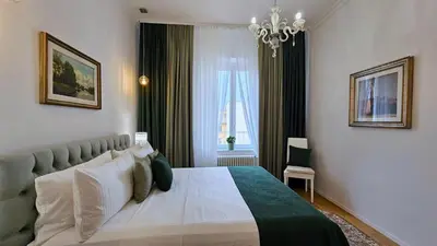 a bedroom with a large bed and a chandelier at Val's Vatican Wall Apartment in Rome