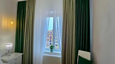 a room with a window with green curtains at Val's Vatican Wall Apartment in Rome
