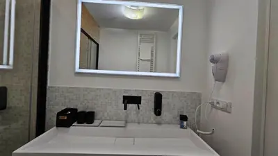 a bathroom with a white sink and a mirror at Val's Vatican Wall Apartment in Rome