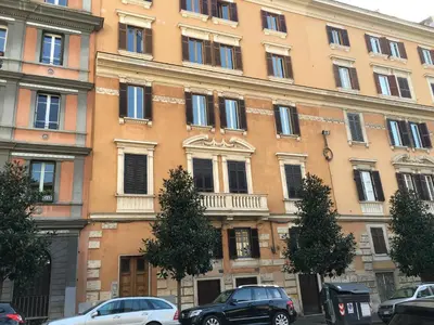 a large building with cars parked in front of it at Residenza San Martino in Rome