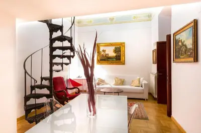 a spiral staircase in a living room with a vase at Trevispagna Charme Apartment Autonomous in Rome