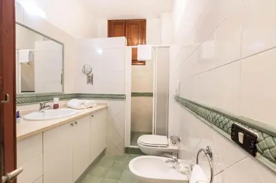 a white bathroom with two sinks and a toilet at Trevispagna Charme Apartment Autonomous in Rome