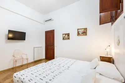 a white bedroom with a bed and a tv at Trevispagna Charme Apartment Autonomous in Rome