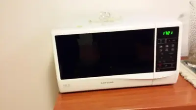 a microwave sitting on top of a wooden table at Trevispagna Charme Apartment Autonomous in Rome