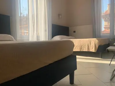 a bedroom with two beds and a window at Residenza Cernaia in Rome