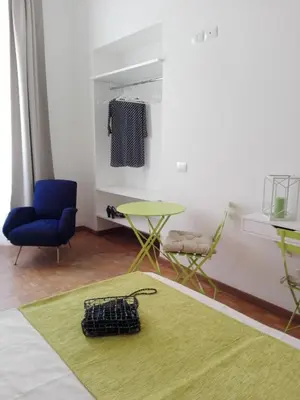 a living room with a green rug and a table and chairs at Domus Crescenzio - Guest House in Rome