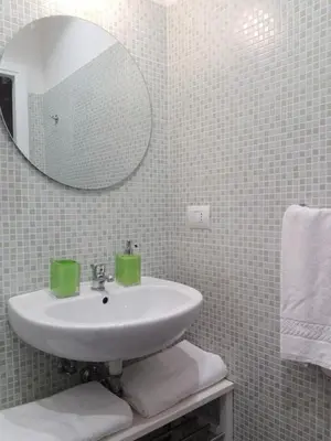 a white bathroom with a sink and a mirror at Domus Crescenzio - Guest House in Rome