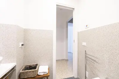 a bathroom with a walk in shower next to a white wall at Trastevere Lovely 2 BR Apartment in Rome