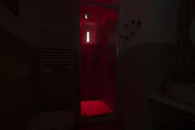 a dark bathroom with a red light in the shower at Trastevere Lovely 2 BR Apartment in Rome