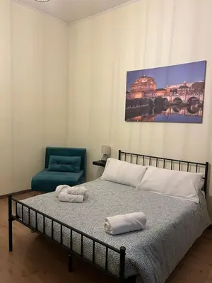 a bedroom with a bed and a blue chair at Domus Marrana - 15 minutes far away from Coloseum in Rome