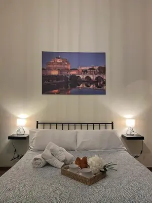 a bedroom with a bed with towels and a painting on the wall at Domus Marrana - 15 minutes far away from Coloseum in Rome