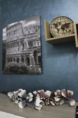 a wall with a picture and flowers on a shelf at Domus Marrana - 15 minutes far away from Coloseum in Rome