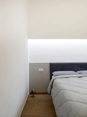 a bedroom with a bed and a white wall at Stans Dolce Lusso Basilica San Giovanni in Rome