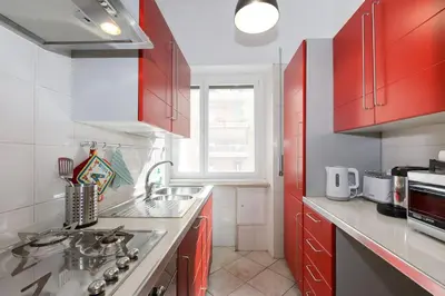 a kitchen with red cabinets and a sink at vatican house in Rome