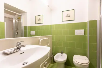 a green bathroom with a sink and a toilet at Frattina Atmosphere by Rental in Rome in Rome