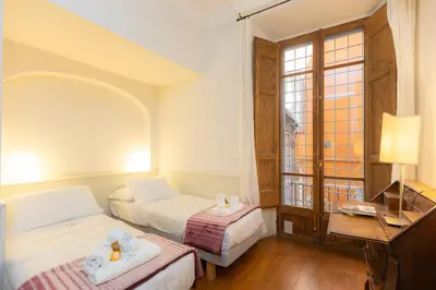 a bedroom with two beds and a desk and a window at Frattina Atmosphere by Rental in Rome in Rome