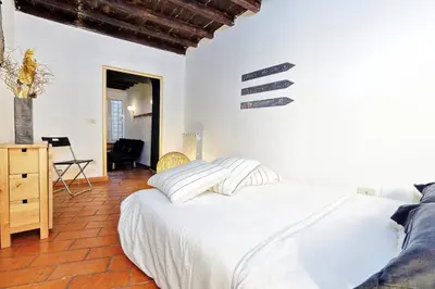 a bedroom with a large white bed and a chair at 3Chic Maison Colosseo in Rome