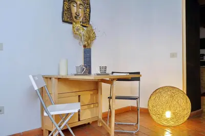 a desk with a chair and a table with a vase at 3Chic Maison Colosseo in Rome