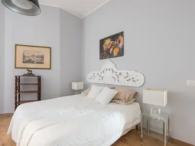 a white bedroom with a white bed and a table at Auditorium Luxury Apartments in Rome