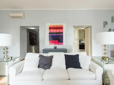 a living room with a white couch with pillows at Auditorium Luxury Apartments in Rome