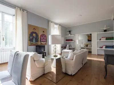 a living room with two white chairs and a table at Auditorium Luxury Apartments in Rome