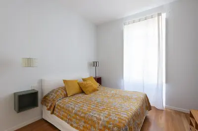a bedroom with a bed with yellow pillows and a television at Auditorium Luxury Apartments in Rome