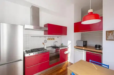 a kitchen with red cabinets and a stainless steel stove at Auditorium Luxury Apartments in Rome