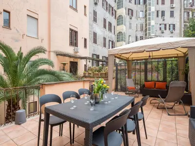 a patio with a table and chairs on a balcony at The Best Rent – Charming flat near Colosseo in Rome