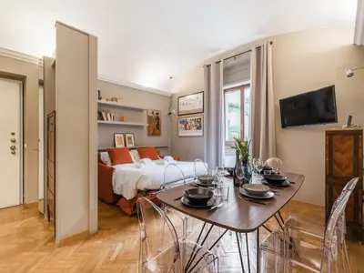 a room with a bed and a table with chairs at The Best Rent – Charming flat near Colosseo in Rome
