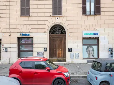a red car parked in front of a building at The Best Rent – Charming flat near Colosseo in Rome