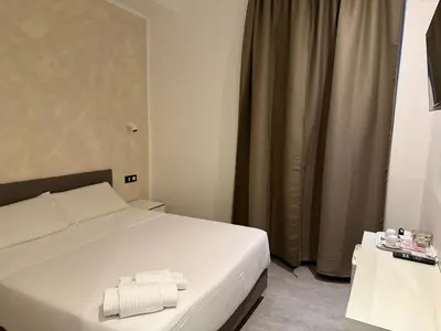 a bedroom with a bed with two towels on it at Relais Merulana Guest House in Rome