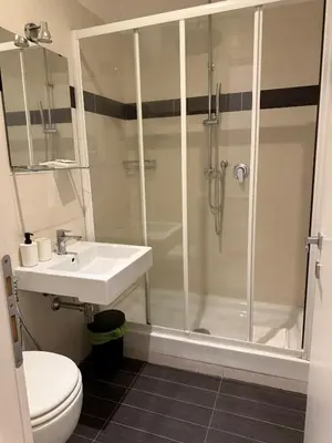 a bathroom with a shower and a sink and a toilet at Relais Merulana Guest House in Rome