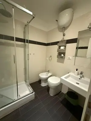 a bathroom with a toilet and a sink and a shower at Relais Merulana Guest House in Rome