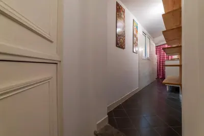 a hallway with white walls and a black tile floor at GuestHost - Fori Imperiali Pretty Apartment in Rome
