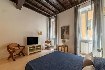 a bedroom with a blue bed and a tv at GuestHost - Fori Imperiali Pretty Apartment in Rome