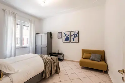 a living room with a table and a chair at The Best Rent – Bright three-bedroom apartment along the Tiber River in Rome