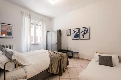 a white kitchen with white cabinets and appliances at The Best Rent – Bright three-bedroom apartment along the Tiber River in Rome